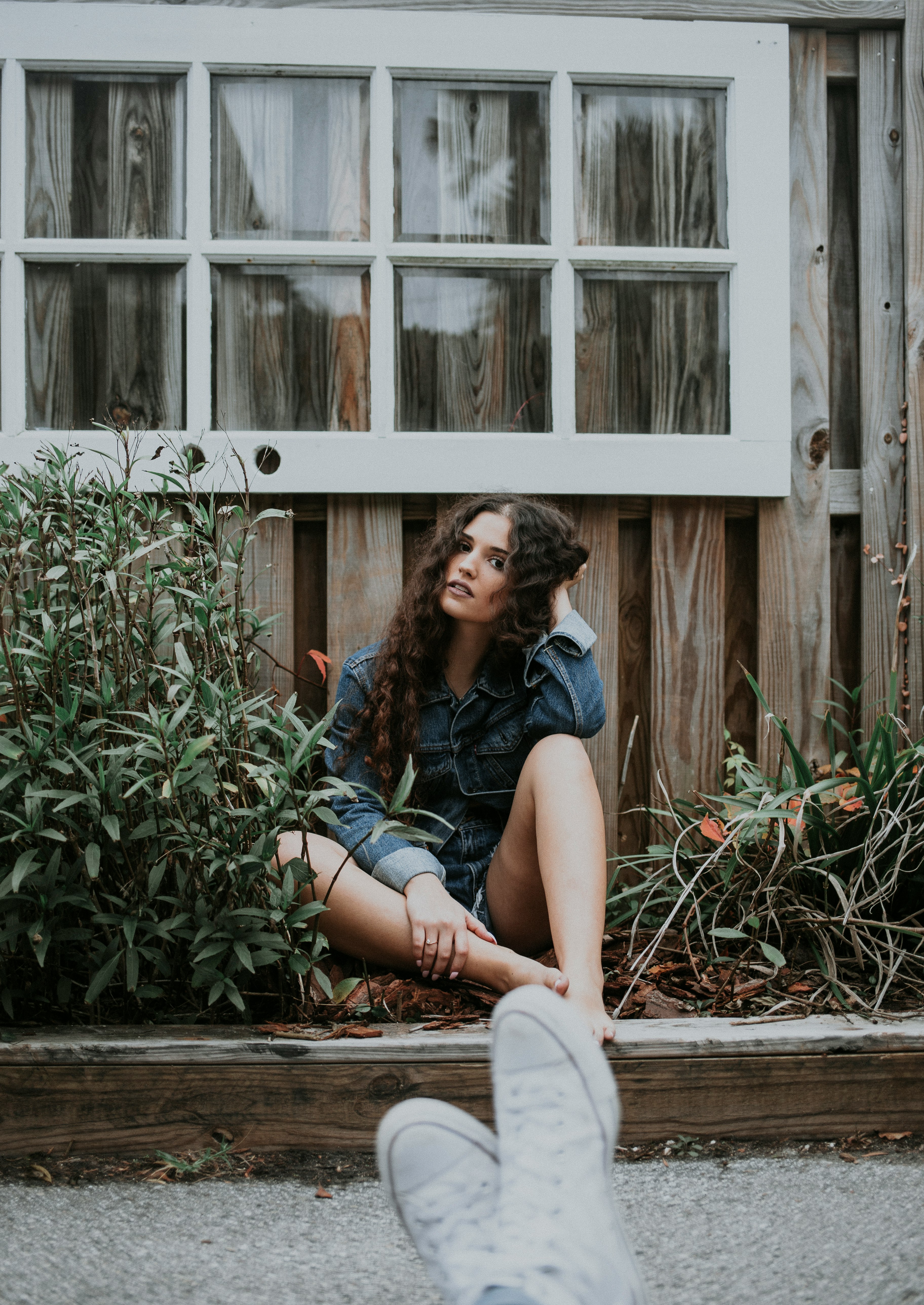 woman sitting under white wooden window